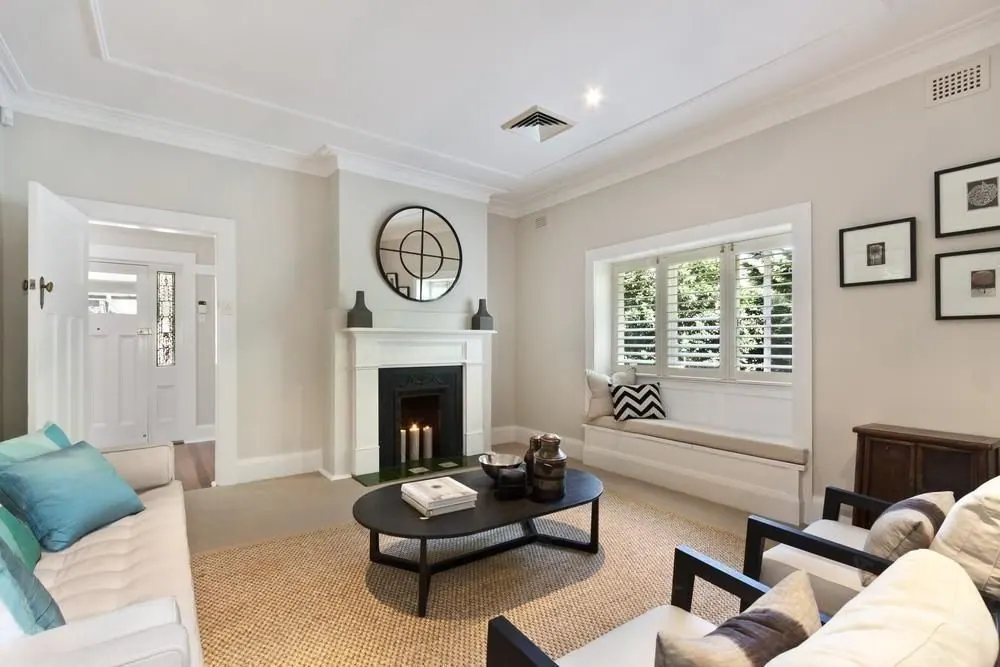 A finished living room with a fireplace, white walls and a sofa